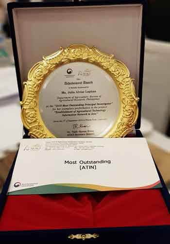 Photo shows the award given to Bureau of Agricultural Applied Communications Division head Julia Lapitan by the Agricultural Technology Information Network (ATIN) in Asia for being named the 2018 Most Outstanding Principal Investigator (PI) of the ATIN project in the Philippines. Lapitan bested PIs from 13 other countries. BAR PHOTO